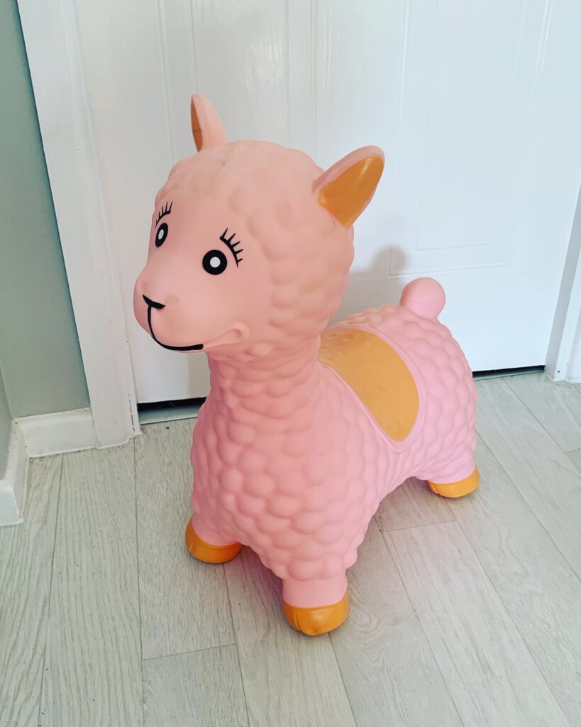 A child's ridable bouncy animal hopper in the form of a pink llama